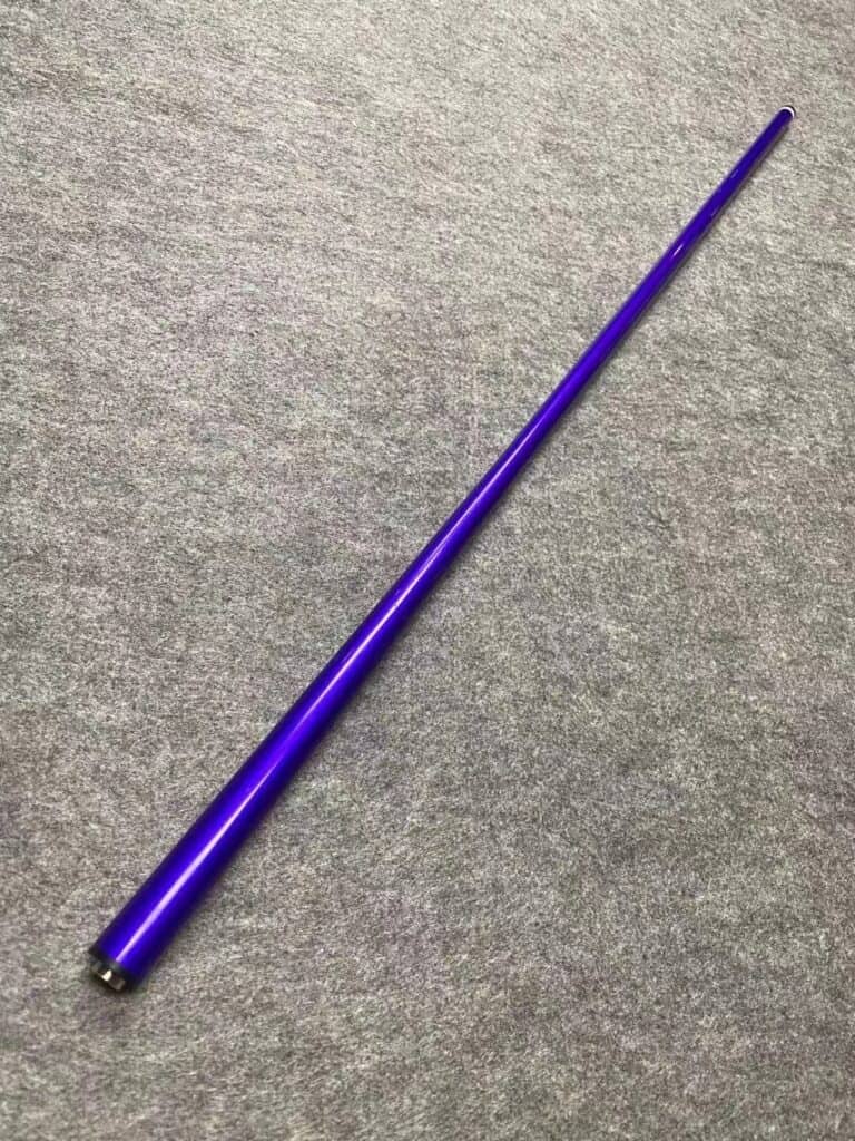 A Purple carbon fiber billiards cue with a black tip, resting on a green felt billiards table.